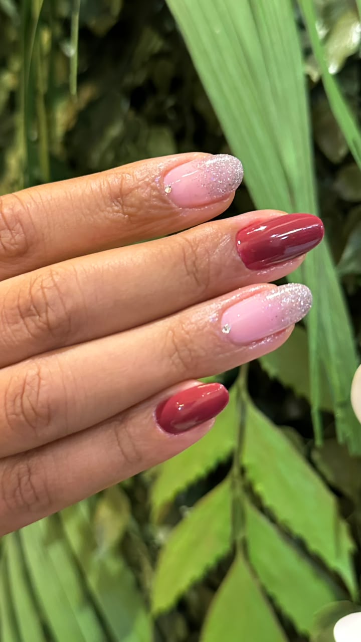 Unhas decoradas com esmaltação em tons de rosa e vermelho